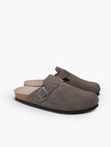 Zueco Genuins Riva  de piel serraje color gris con planta anatómica de caucho corcho y hebilla ajustable metálica para hombre vista lateral doble.
